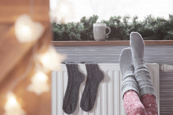 Woman warming up with feet on heater