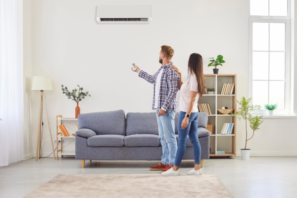 couple turning on newly installed ductless air conditioner