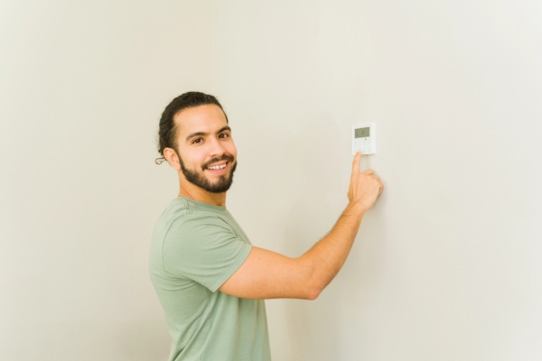 man adjusting home thermostat