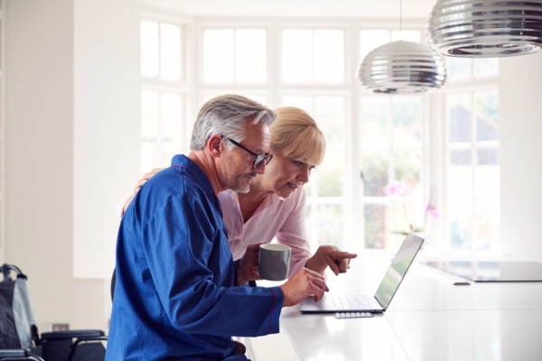 couple researching about HVAC company using laptop