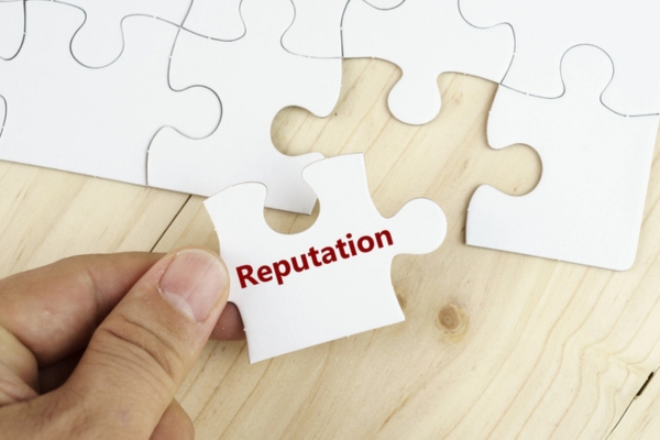 hand holding a puzzle piece that says reputation