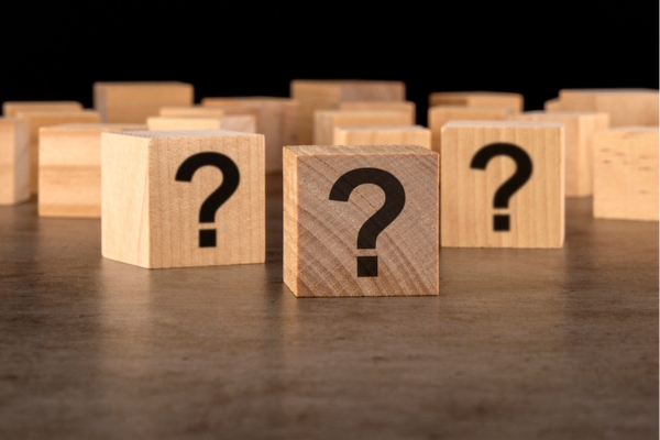 question marks on wooden cubes depicting Air Conditioner Replacement Company FAQs