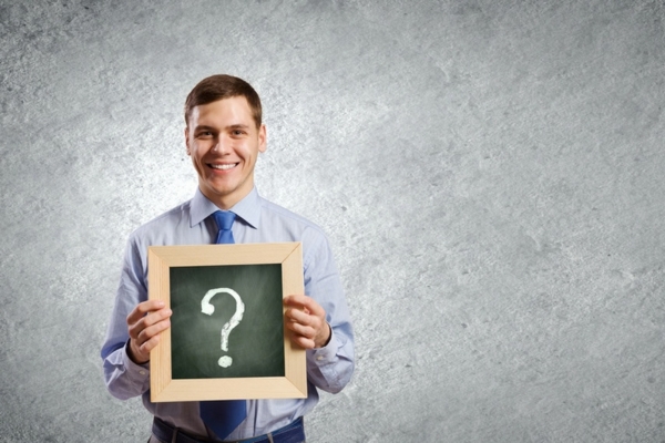 man holding a mini chalkboard with question mark depicting Questions About Oil Heating Costs